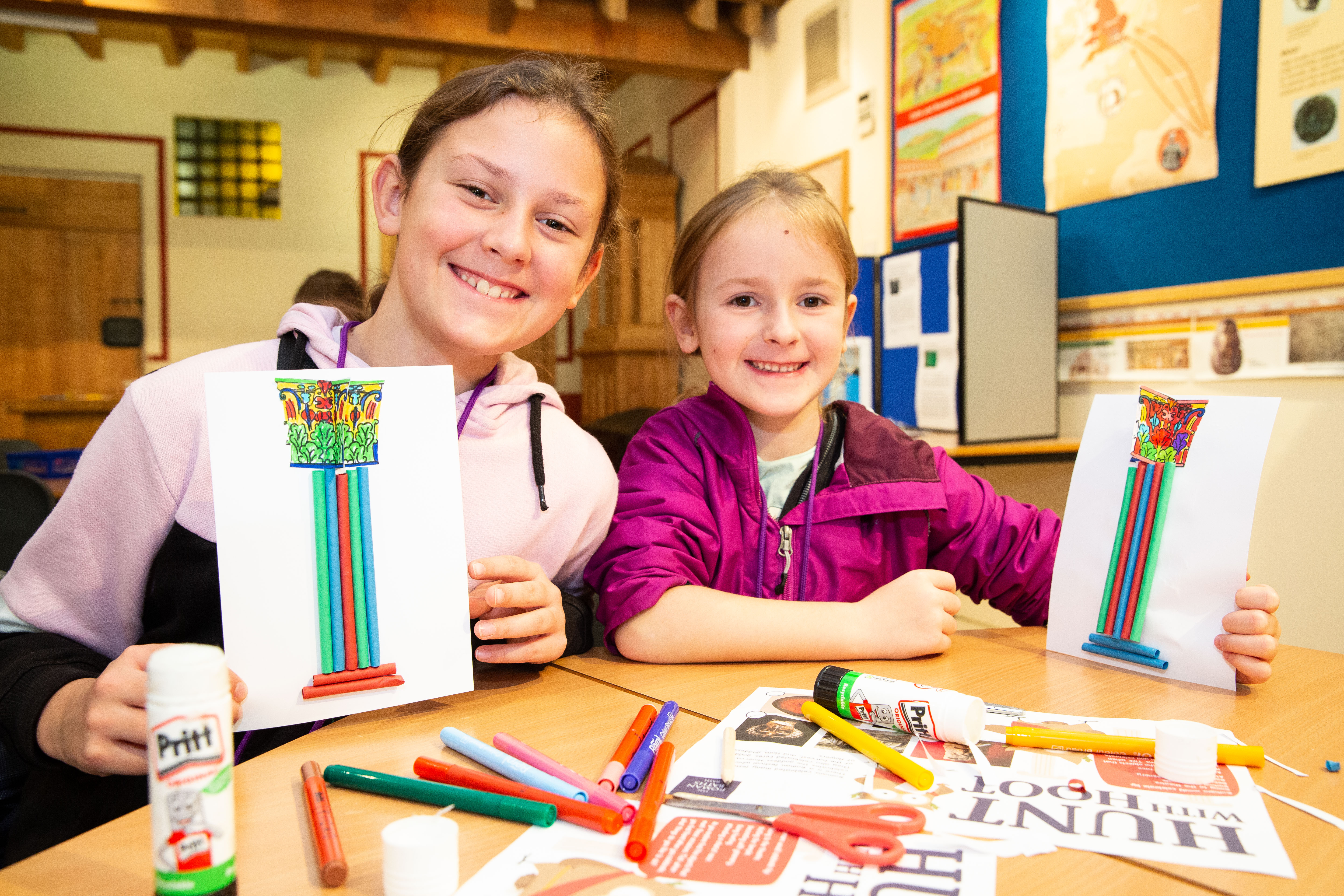 Children showing their artwork at an activity at the Roman Baths